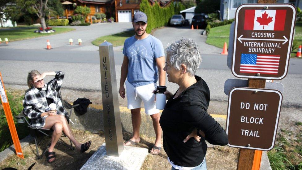 Chelsea Perry, left, and husband Garrick Perry of Calgary, Alberta meet with friend Alison Gallant of Bellingham, Washington from opposite sides of the USA-Canada border