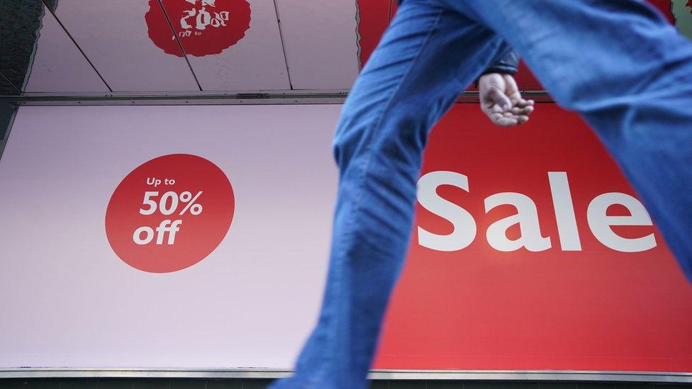 A shopper walks past Boxing Day sale signs in 2022