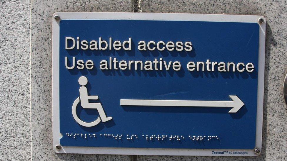 Disabled access notice in Braille to use alternative entrance