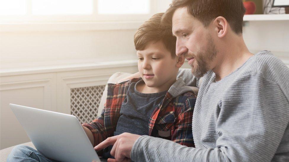 Man and boy looking at computer.