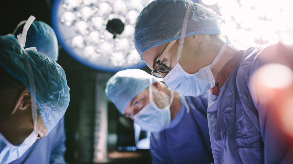 Surgeons in an operating theatre.