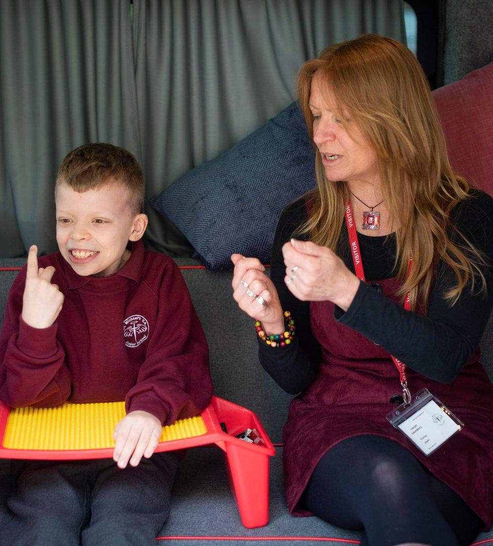 Oliver explains his Lego invention to mentor Caryn