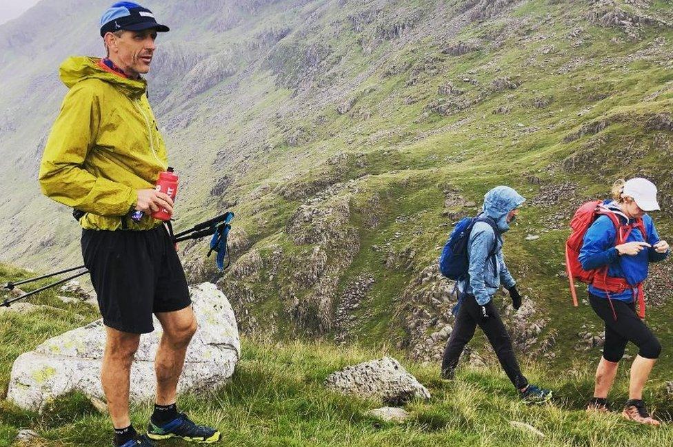 Kirk and two friends have a drink on a mountain side