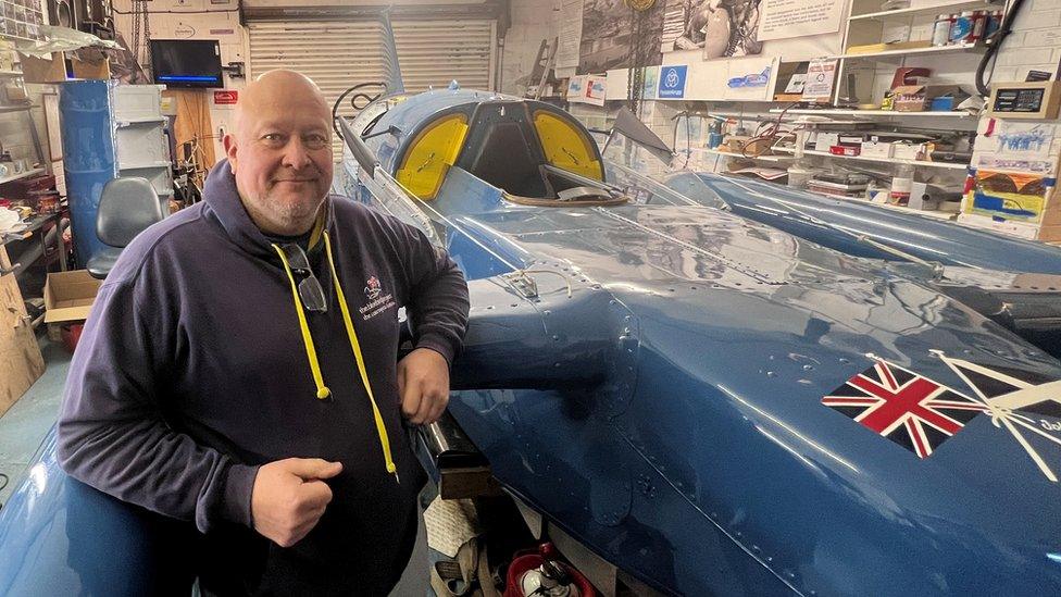 Bill Smith standing next to Bluebird in his North Shields workshop