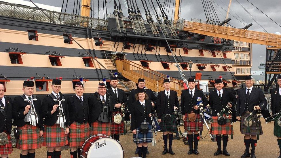 Irene Robinson standing beside HMS Victory in Portsmouth