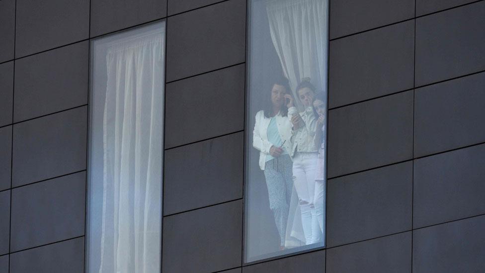 people looking from a hotel window