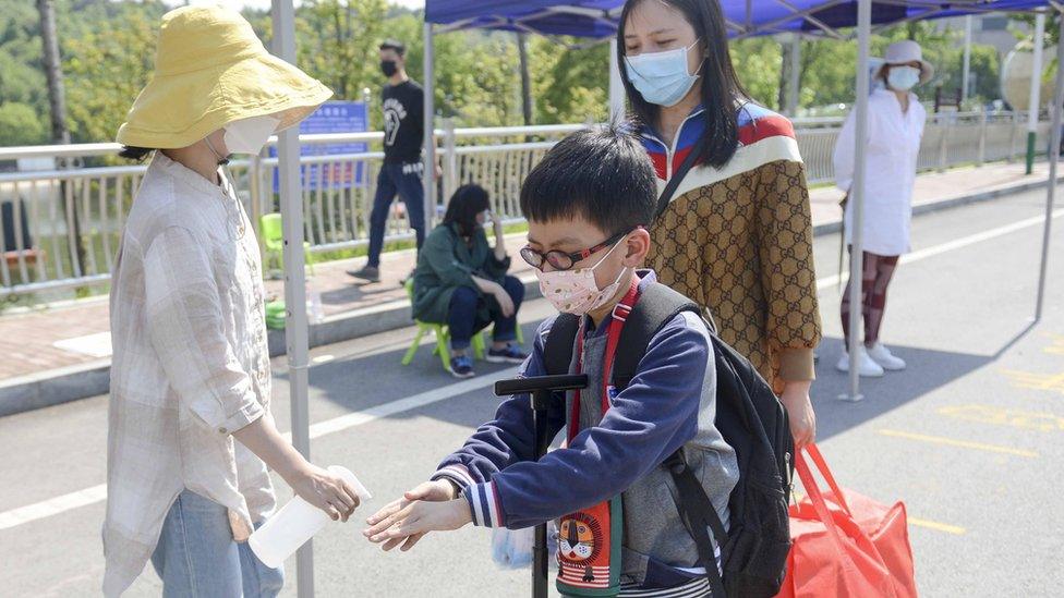 A-school-child-having-his-hand-sanitized.