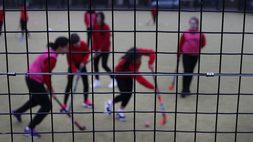 Secondary school children playing hockey