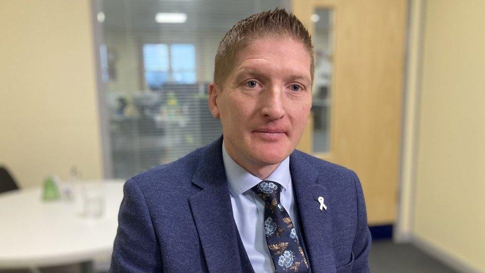 Executive Chief Inspector Phil Walker sitting down wearing a blue suit