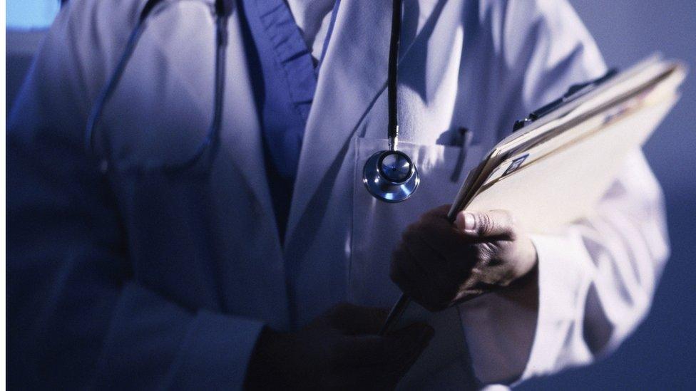 A doctor holding some patient files