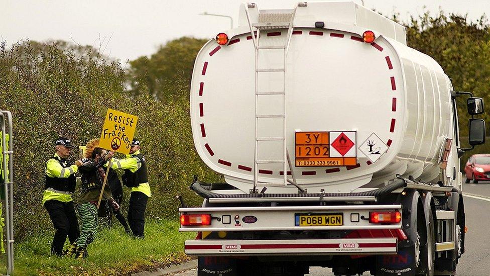 Police detain protestors near a lorry