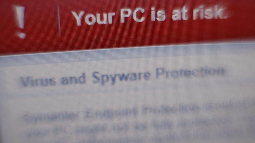 A virus and spyware warning message on a laptop screen