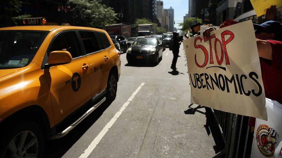 Protestor with 'Stop Ubernomics' placard