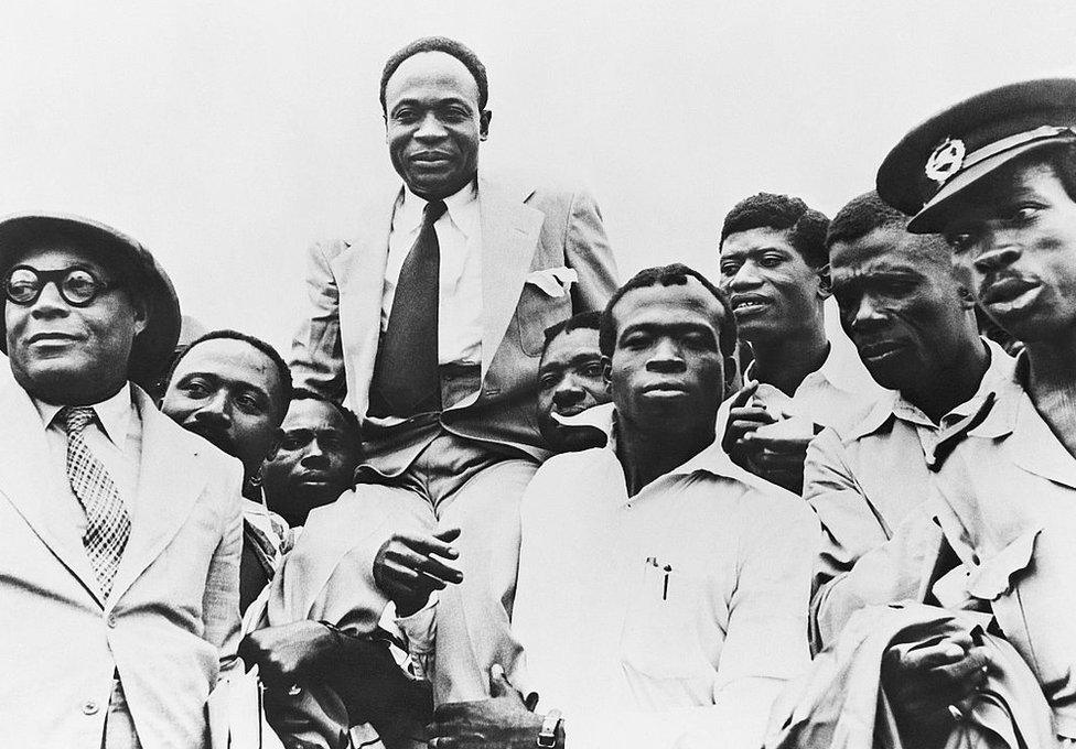 Government officials carry Prime Minister and President Kwame Nkrumah on their shoulders after Ghana obtains its independence from Great Britain.