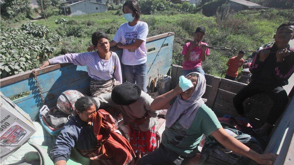 Villagers board a truck as they are transported from their homes too close to the danger zone following the eruption of Mount Sinabung in Gamber village, North Sumatra, Indonesia, Sunday 22 May 2016.