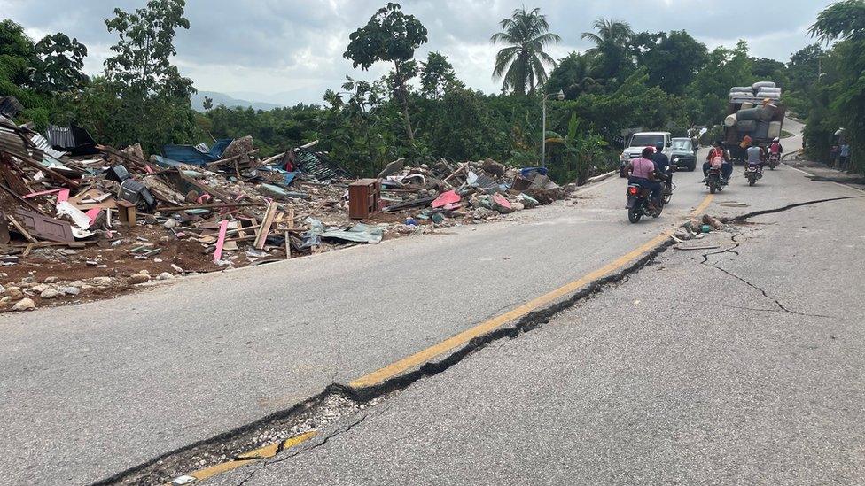 Motorists try to avoid cracks on a road in Marceline, Haiti