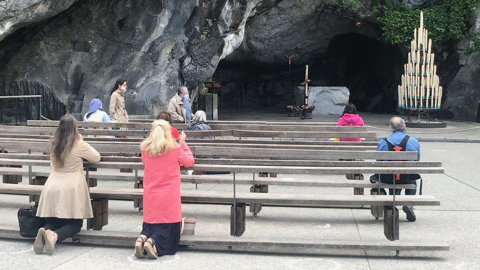 Worshippers pray at the grotte in Lourdes