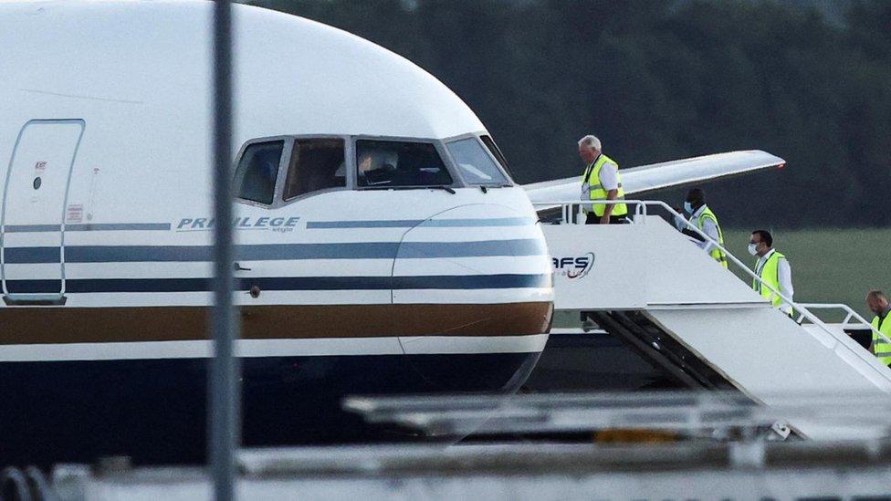 Members of the staff board a plane reported by British media to be first to transport migrants to Rwanda, at MOD Boscombe Down in June