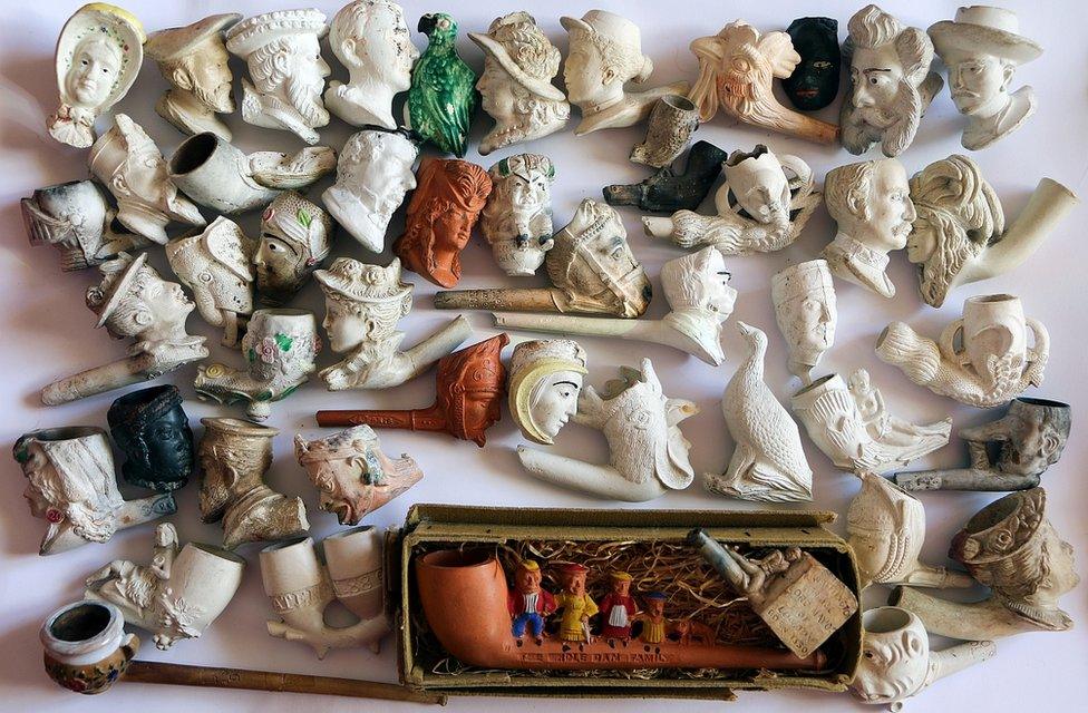 Ornate clay pipes cast as various human heads