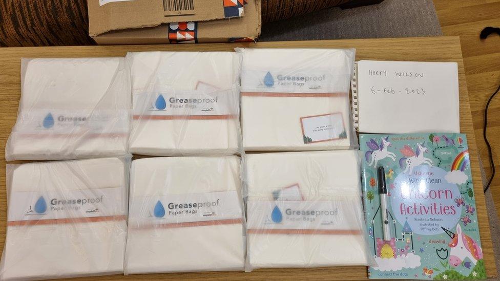 a parcel containing greaseproof bags and a children's colouring book.