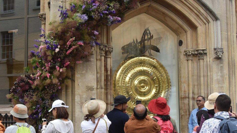 Tourists crowded round the newly returned Corpus Chronophage in Cambridge