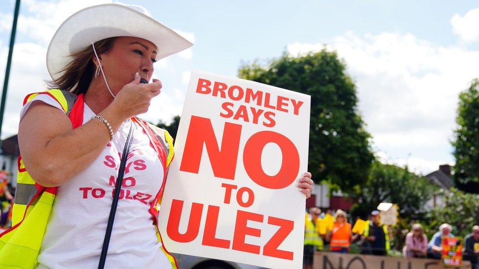 Woman holding 'Bromley says no to Ulez' sign