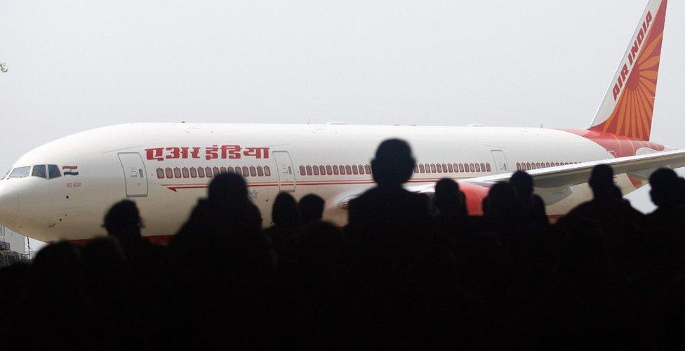 Air India employees look at the newly acquired Boeing 777-200 LR aircraft, 'ASSAM', as it stands on the tarmac of the Chattrapati Shivaji International airport in Mumbai, 30 July 2007, on the eve of Air India?s inaugural non-stop operations in the Mumbai-New York sector. I