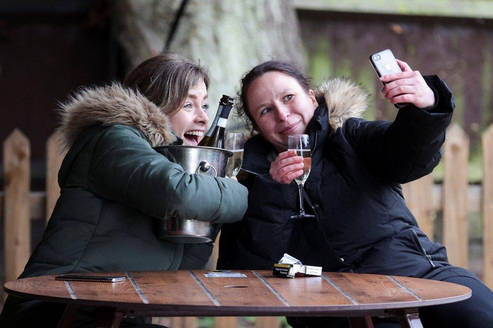 Women take a selfie with their drinks