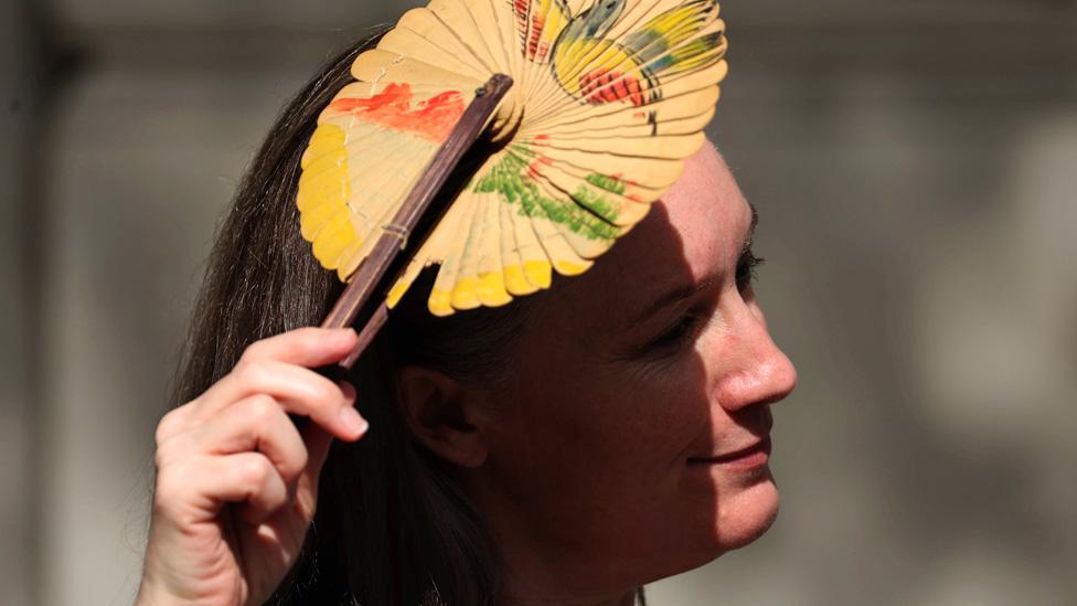 A woman shades herself from the sun