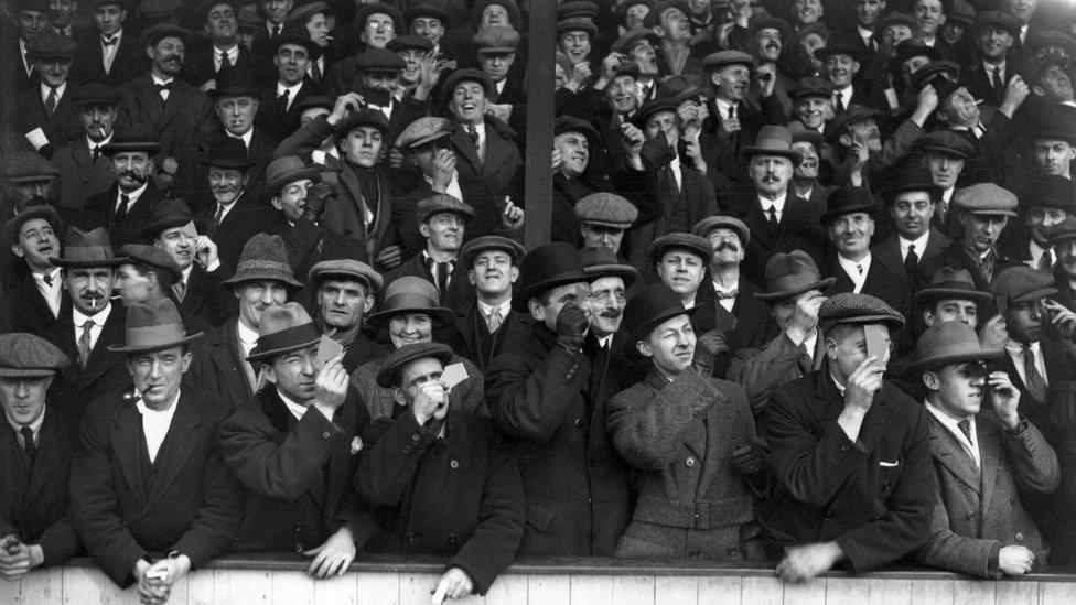 Fans watching West Ham United play Aston Villa, on 4 April 1936, view the eclipse of the sun during play