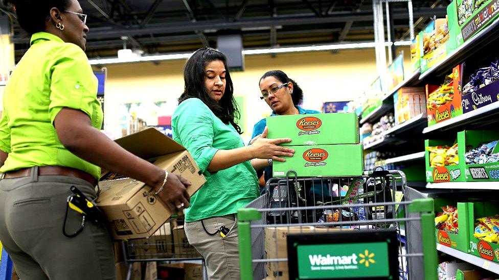 Walmart staff stock shelves in the supermarket