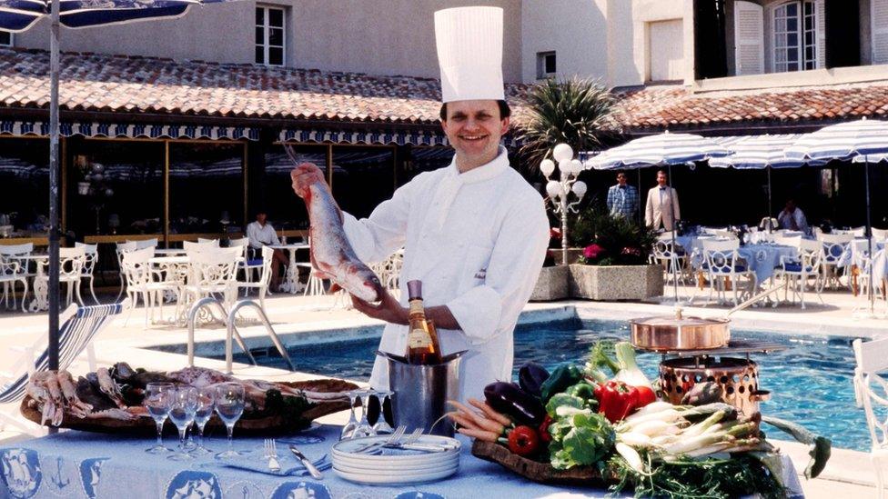 May 18, 1984, French chef Joel Robuchon poses holding a fish in Port Grimaud, south-eastern France