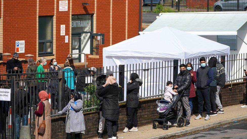 People queue for Covid-19 vaccinations at a mobile vaccination clinic set up at the Masjid E Sajedeen Mosque in Blackburn, England.