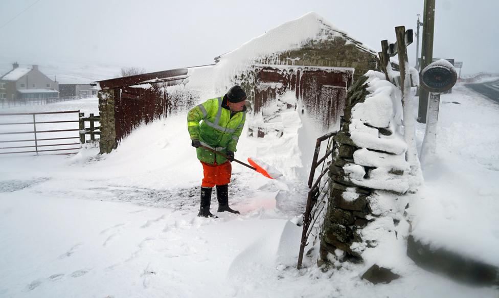 A man clears a snow drift in Lanehead, County Durham, 21 January 2021