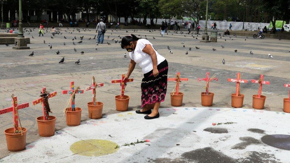 A woman tends to the monument in Guatemala City