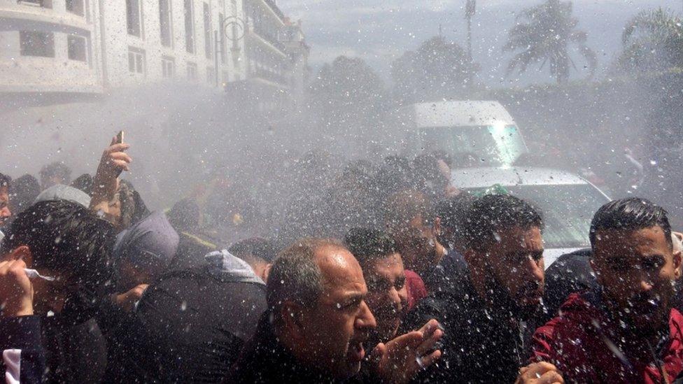 Crowds are seen being wet by police