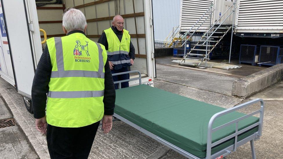 Two men in high viz jackets loading bed