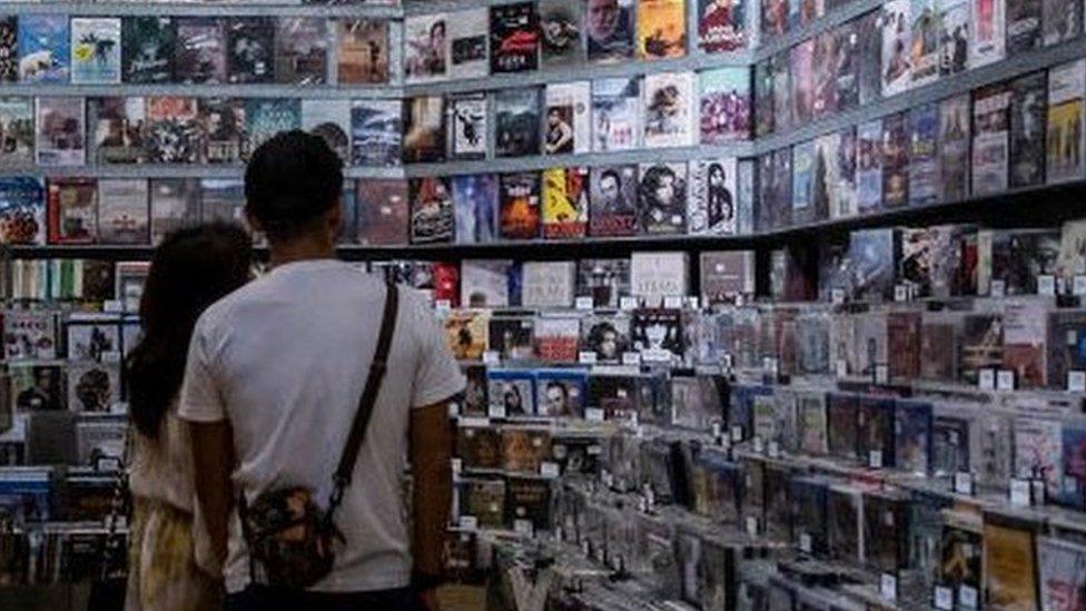 Customers looking at movies for sale at a store inside a cinema in Hong Kong on 2 September