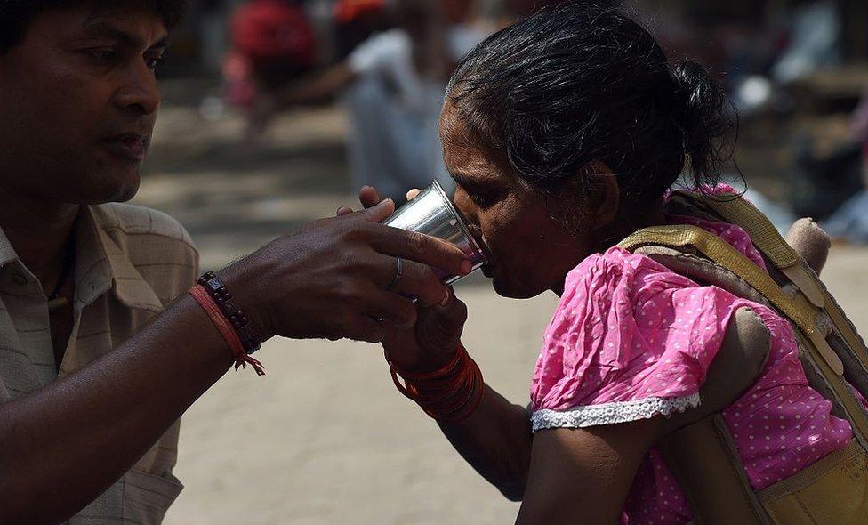 Sunil Singh helps his cancer-affected wife Sunita with her medication on the footpath outside a hospital home on World Cancer Day in Mumbai on February 4, 2015. Singh, hailing from the eastern Indian state of Bihar, is one among various Indian cancer patients who are forced to live on the streets outside the hospital because they cannot afford a place to stay during their treatment in Mumbai.