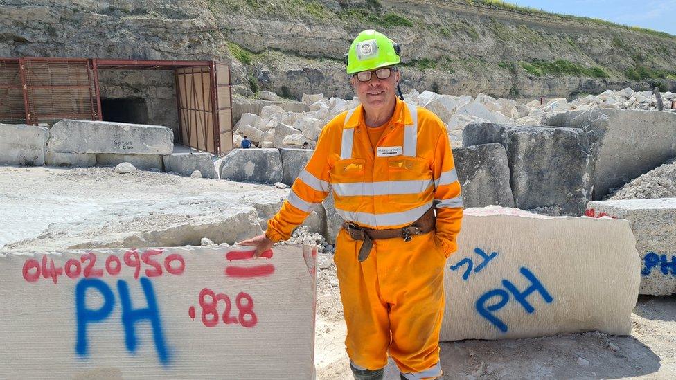 Mine manager Mark Godden in Bowers Quarry, wearing orange hi-vis and a hard hat