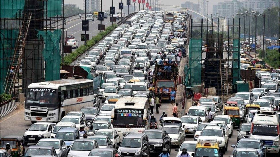 In this photograph taken on August 1, 2016, Indian commuters and their vehicles stand in a traffic jam in New Delhi