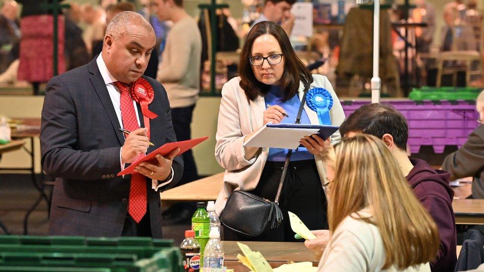 Members of the Labour and Conservative parties observe as ballots are counted