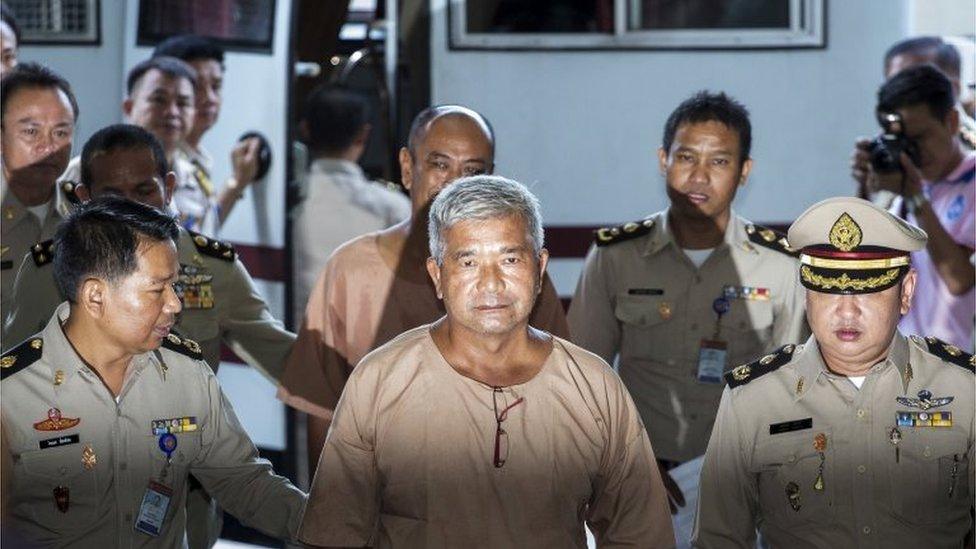 Lieutenant General Manas Kongpan (C) is escorted by officers as he arrives at the criminal court in Bangkok, Thailand, November 10, 2015.