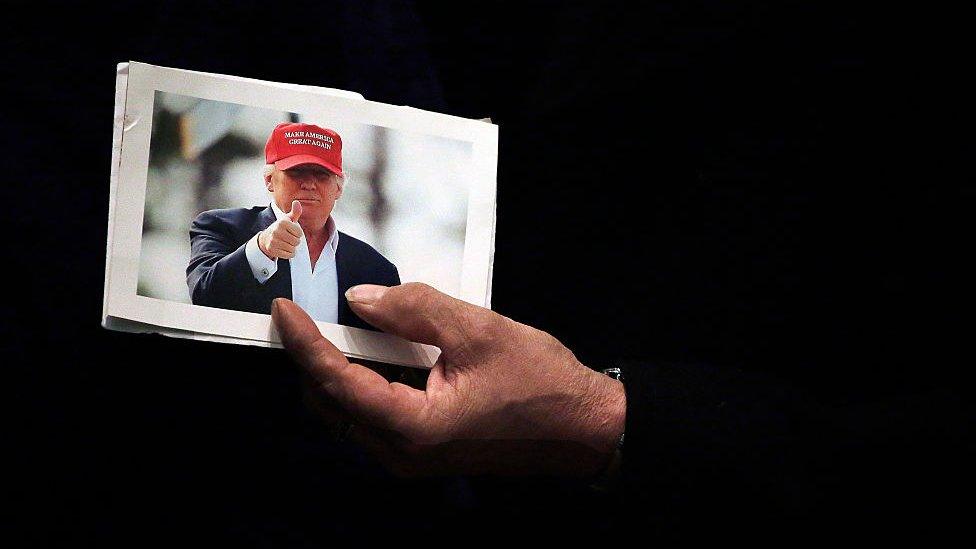 A man holds a picture of Republican presidential candidate Donald Trump at the rope line during a campaign event at the U.S. Cellular Convention Center February 1, 2016 in Cedar Rapids, Iowa.