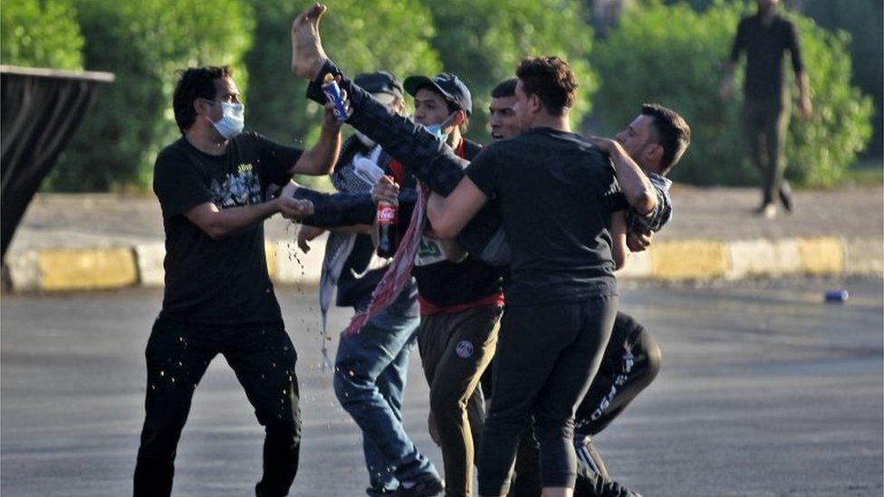 Protesters carry a wounded demonstrator in Baghdad (05/10/19)