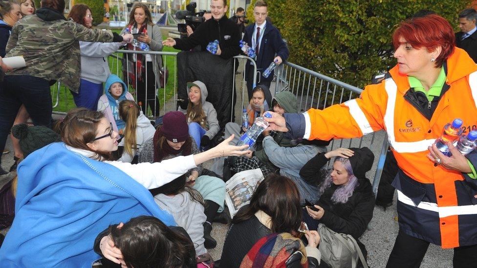 Stewards at the SSE Arena hand out water to queuing fans