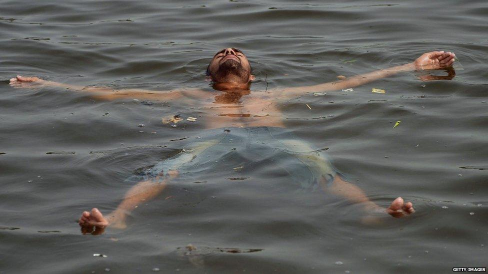 A Pakistani youth cools off in the sea during a heatwave in Karachi 22 June 2015