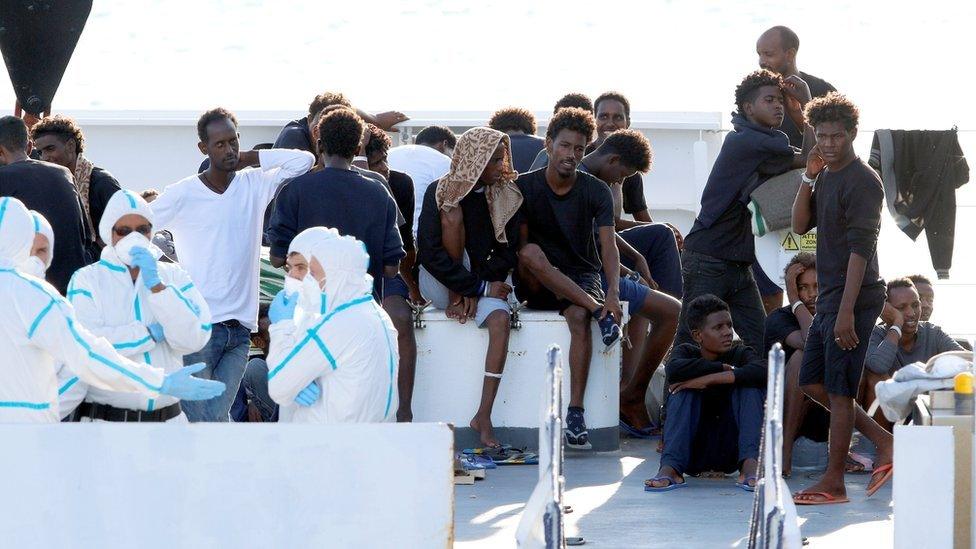 Migrants wait to disembark from the Italian coast guard vessel Diciotti at the port of Catania, Italy, August 22, 2018