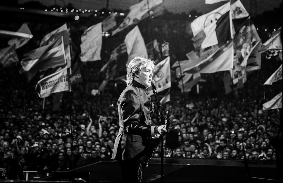 Sir Paul silhouetted against Glastonbury's flags