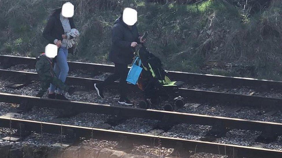 People walking along railway line